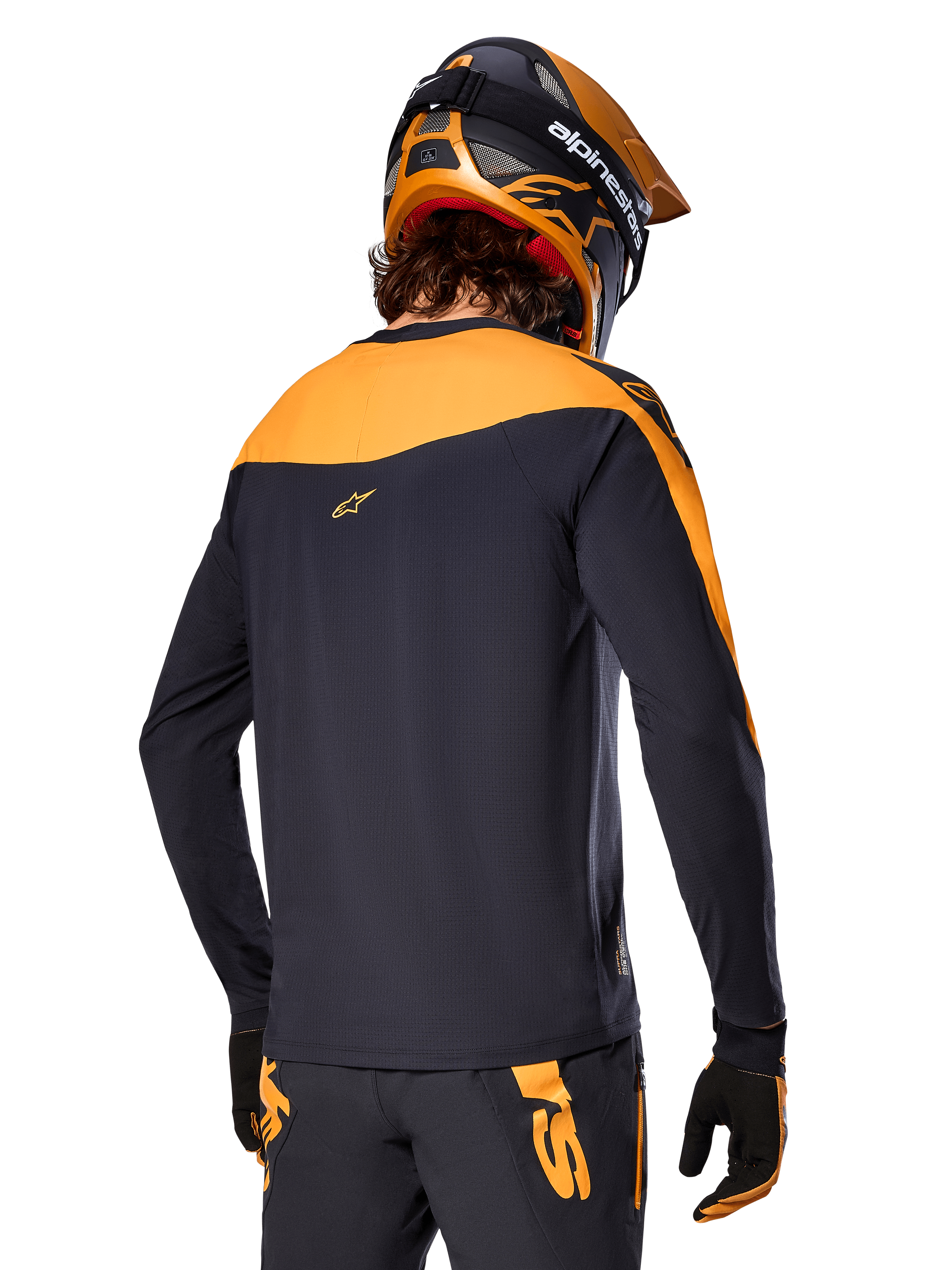 Alpinestars A-Supra Race Jersey - Langærmet, sort og orange, set bagfra af rytter iført matchende hjelm og mountainbike-bukser, performance-pasform med mikroperforeret tekstur, professionelt MTB-racerudstyr
