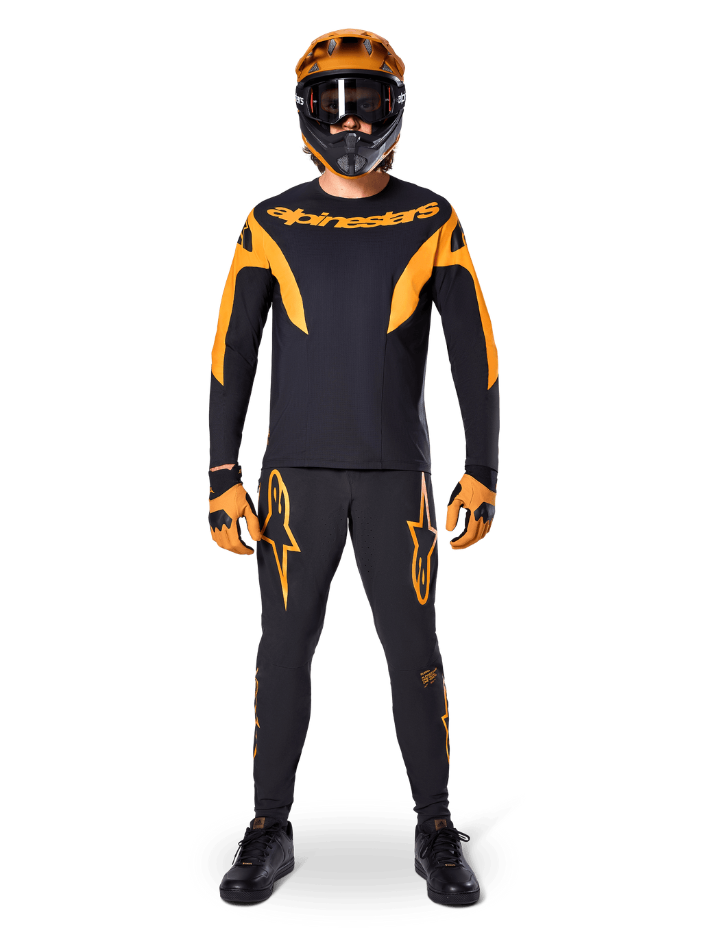 MTB-rytter iført Alpinestars A-Supra Race langærmet trøje i sort og orange, matchende sorte og orange bukser, handsker og en full-face hjelm med goggles, koordineret mountainbike-udstyr til racing og off-road performance