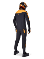 Alpinestars A-Supra Race langærmet trøje, sort og orange, set bagfra af en rytter iført matchende MTB-bukser, orange og sort hjelm og handsker, performance-udstyr til mountainbike-racing