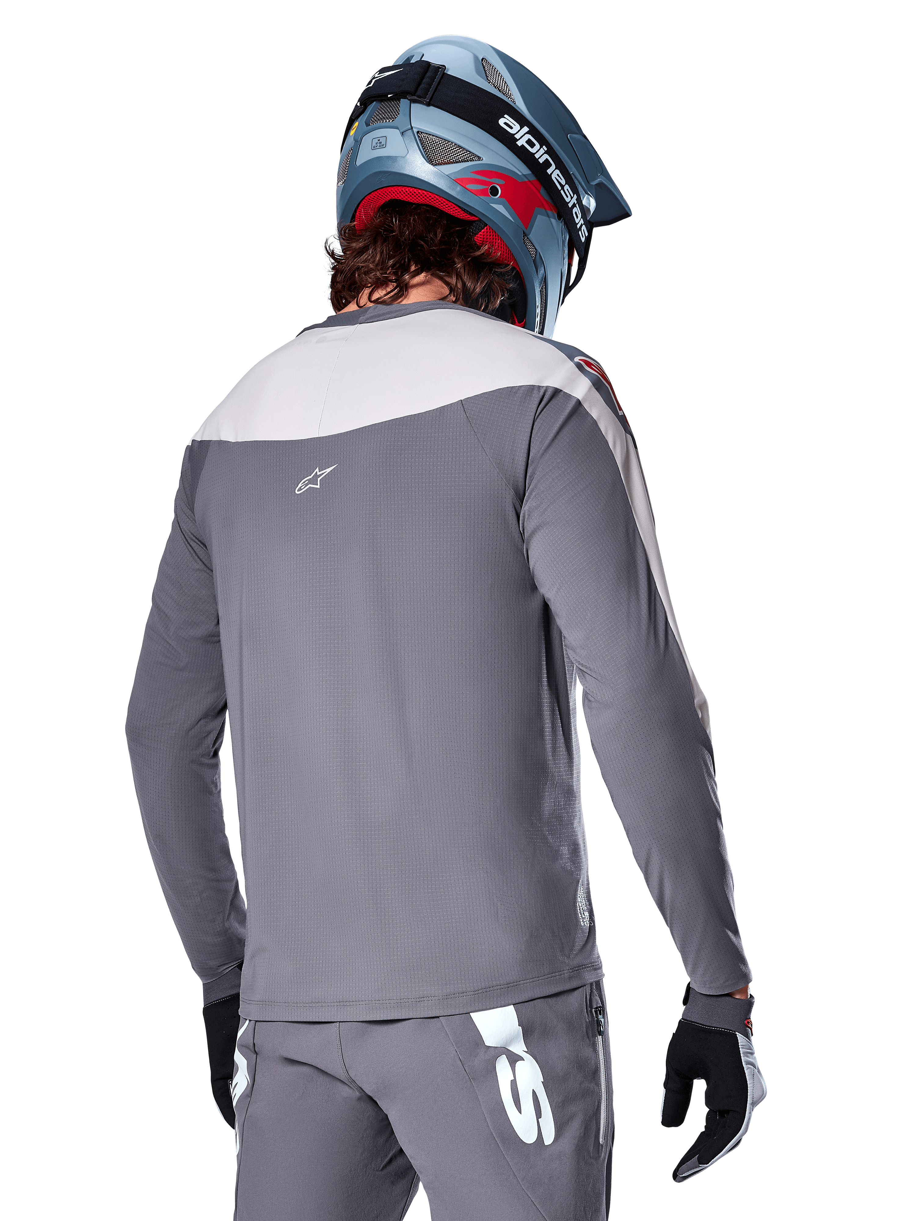 Alpinestars A-Supra Race Jersey, langærmet MTB-trøje i mørkegrå og lysegrå, set bagfra viser performance-pasform og Astar-logo, matchende grå bukser og blå mountainbike-hjelm, designet til off-road mountainbiking