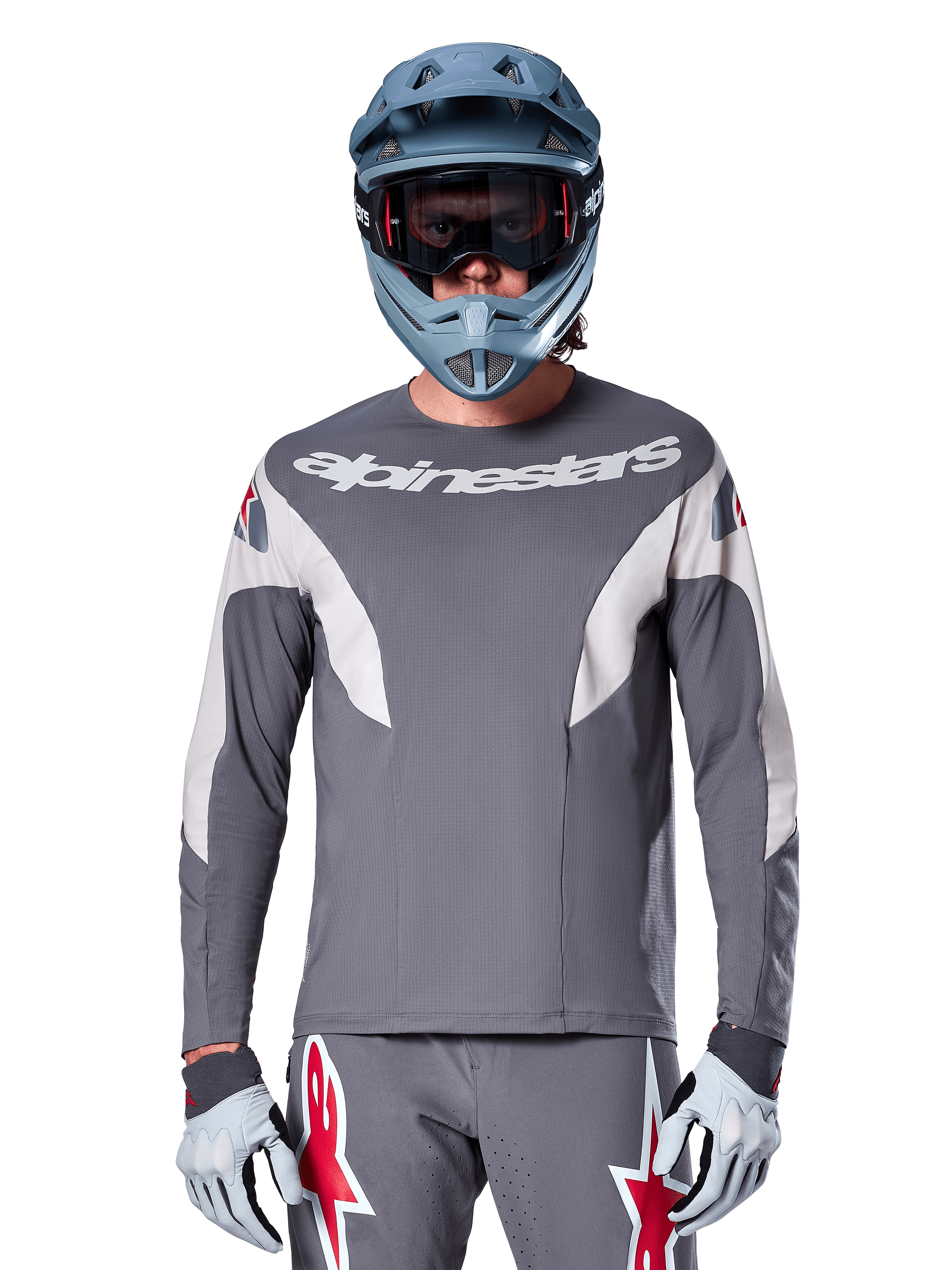 MTB-rytter iført Alpinestars A-Supra Race Jersey - Long Sleeve i Dark Gray, langærmet cykeltrøje med hvidt Alpinestars-logo, kombineret med blågrå full-face hjelm, goggles og grå racinghandsker, komplet mountainbike-racerudstyr til off-road performance