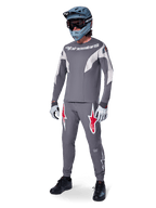 Alpinestars A-Supra Race langærmet jersey, MTB-rytter, mørkegrå med lysegrå detaljer, matchende mørkegrå bukser med rødt stjernelogo, grå full-face hjelm med goggles, lysegrå handsker, koordineret mountainbike-outfit til racing