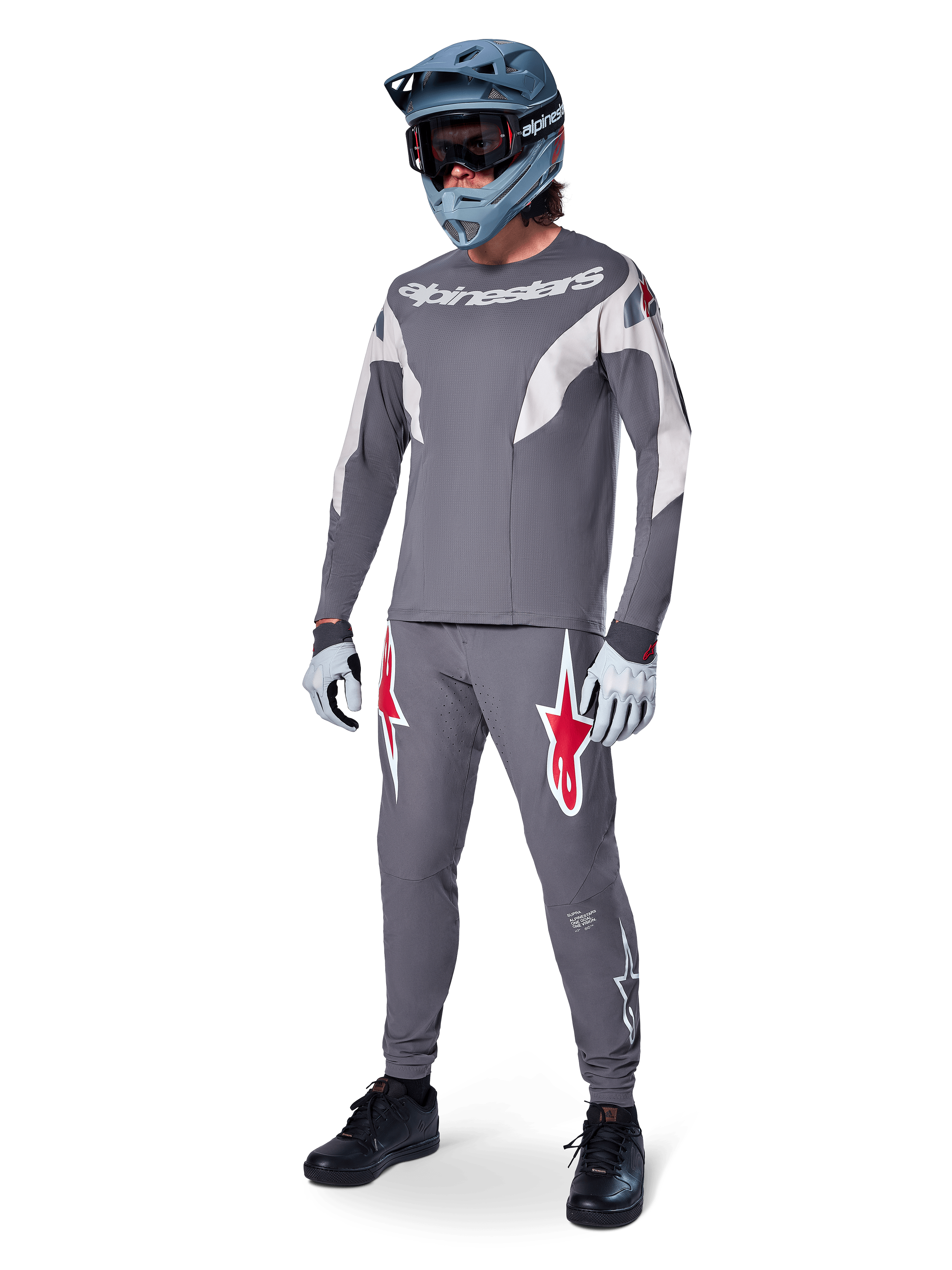 Alpinestars A-Supra Race langærmet jersey, MTB-rytter, mørkegrå med lysegrå detaljer, matchende mørkegrå bukser med rødt stjernelogo, grå full-face hjelm med goggles, lysegrå handsker, koordineret mountainbike-outfit til racing