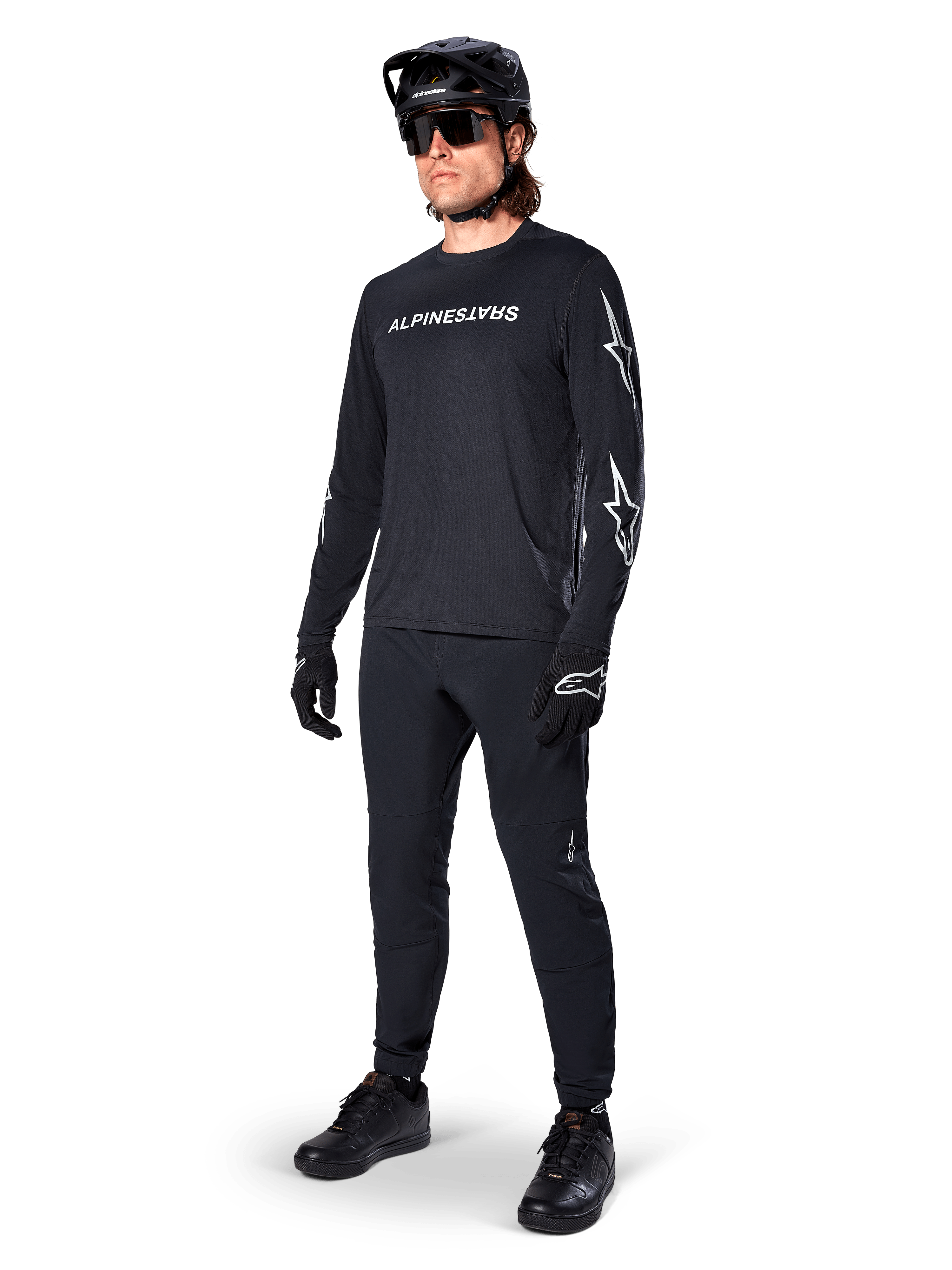 Alpinestars A-Dura Switch Long Sleeve Jersey, Black, mountain bike jersey worn with black pants, helmet, and gloves, featuring white wordmark logo on chest and star logos on sleeves, coordinated MTB gear for off-road riding
