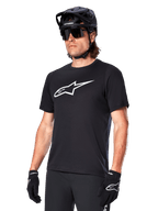 Alpinestars A-Dura Dri Oscar Jersey, Short Sleeve MTB Cycling Shirt, Black with white logo, moisture-wicking performance fabric, worn with black helmet, sunglasses, and gloves
