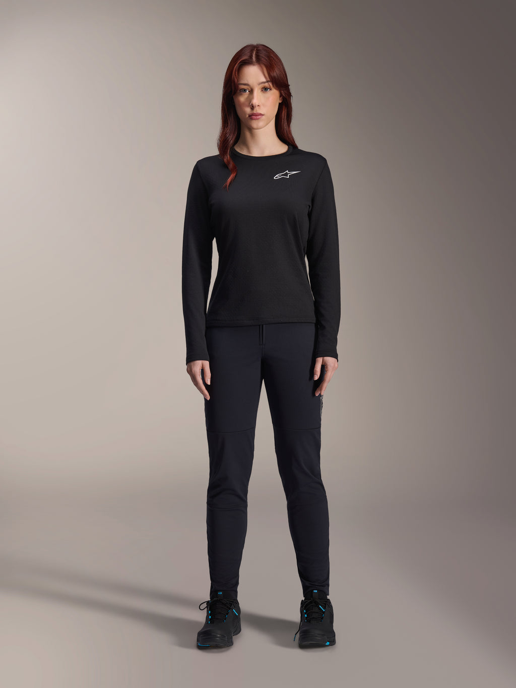 Alpinestars Stella A-Dura Thermal trøje, langærmet mountainbike-trøje til kvinder i sort, med hvidt brystlogo, kombineret med matchende sort udstyr og cykelsko, studioportræt.