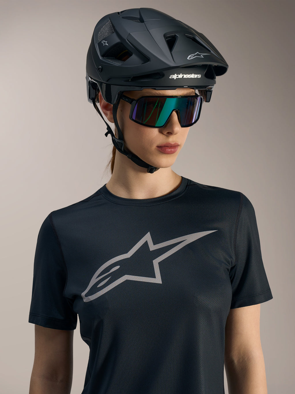 Sort Stella A-Dura Ride kortærmet trøje med gråt logo, vist med MTB-hjelm og solbriller til kvinder.