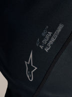 Sort Stella A-Dura Ride trøje med hvidt Alpinestars-logo og A-DURA-branding på jacquard-vævet stof.