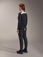Kvindelig rytter iført Alpinestars Stella A-Dura bukser og Stella A-Dura Elite jersey til kvinder, sort, set bagfra med hvide mesh-skulderpaneler på den langærmede jersey, tekniske bukser med tætsiddende pasform, koordineret mountainbike-udstyr