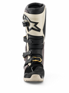 Alpinestars 2026 Tech 7 Enduro Drystar® støvler, sort, mørkegrå og guld, vandtætte off-road motorcykelstøvler, set forfra med multispænde-lukkesystem med guld-detaljer, TPU-skinnebensbeskyttelse og stjernelogo-design.