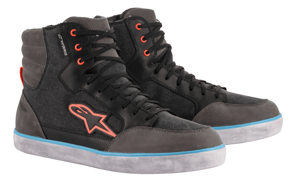 Alpinestars J-6 Waterproof Canvas køresko, sort og antracitgrå, design som en høj sneaker med orange logo og snørehuller, lyseblå stribe på den hvide sål, vandtæt urban motorcykelfodtøj