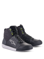 Alpinestars Chrome Drystar® sko, urbane motorcykelsko, sort, mørkegrå og gul fluo, high-top silhuet i førsteklasses læder og ruskind, med hvidt Alpinestars logo og neongule snørebåndsstropper, afslappet beskyttende fodtøj i street-stil