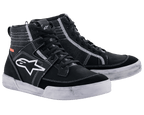 Alpinestars Ageless Riding Shoes, urban motorcykelfodtøj, sort med hvide kontrastsyninger og hvide såler, high-top sneaker-silhuet med et stort hvidt stjernelogo på siden, afslappet beskyttelsesudstyr til landevejskørsel