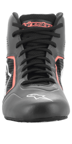 Alpinestars Tech-1 K Start V2 sko, kartingsko, Asphalt Black og Orange Fluo, set forfra viser sorte snørebånd, orange Alpinestars-branding på pløsen, hvidt stjernelogo på snuden og perforerede mikrofiberpaneler