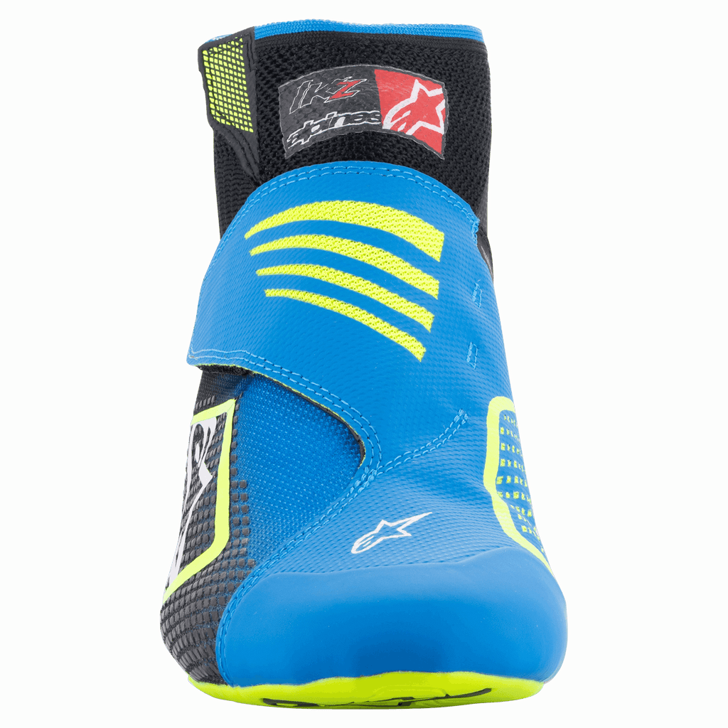Alpinestars Tech-1 KZ V2 sko, kartingsko, sort, emaljeblå og fluorescerende gul, set forfra, viser den sømløse strikkede overdel, klar blå rem med gule detaljer og sort ankelkrave