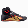 Alpinestars Supermono V2-sko FIA, racingsko til motorsport, sort, guld og rød, profilvisning fra siden, der viser læderkonstruktion med perforerede paneler, stort guldstjerne-logo, elastisk brandsikker krave i sok-stil og en velcro-strop.