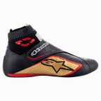 Alpinestars Supermono V2-sko FIA, racingsko til motorsport, sort, guld og rød, profilvisning fra siden, der viser læderkonstruktion med perforerede paneler, stort guldstjerne-logo, elastisk brandsikker krave i sok-stil og en velcro-strop.