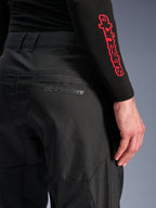 Alpinestars C-1 Air bukser, sorte motorcykelbukser i tekstil, nærbillede af baglommen med et diskret gråt Alpinestars-logo, åndbare mesh-paneler og slidstærkt poly-tekstil, designet til komfort ved bykørsel