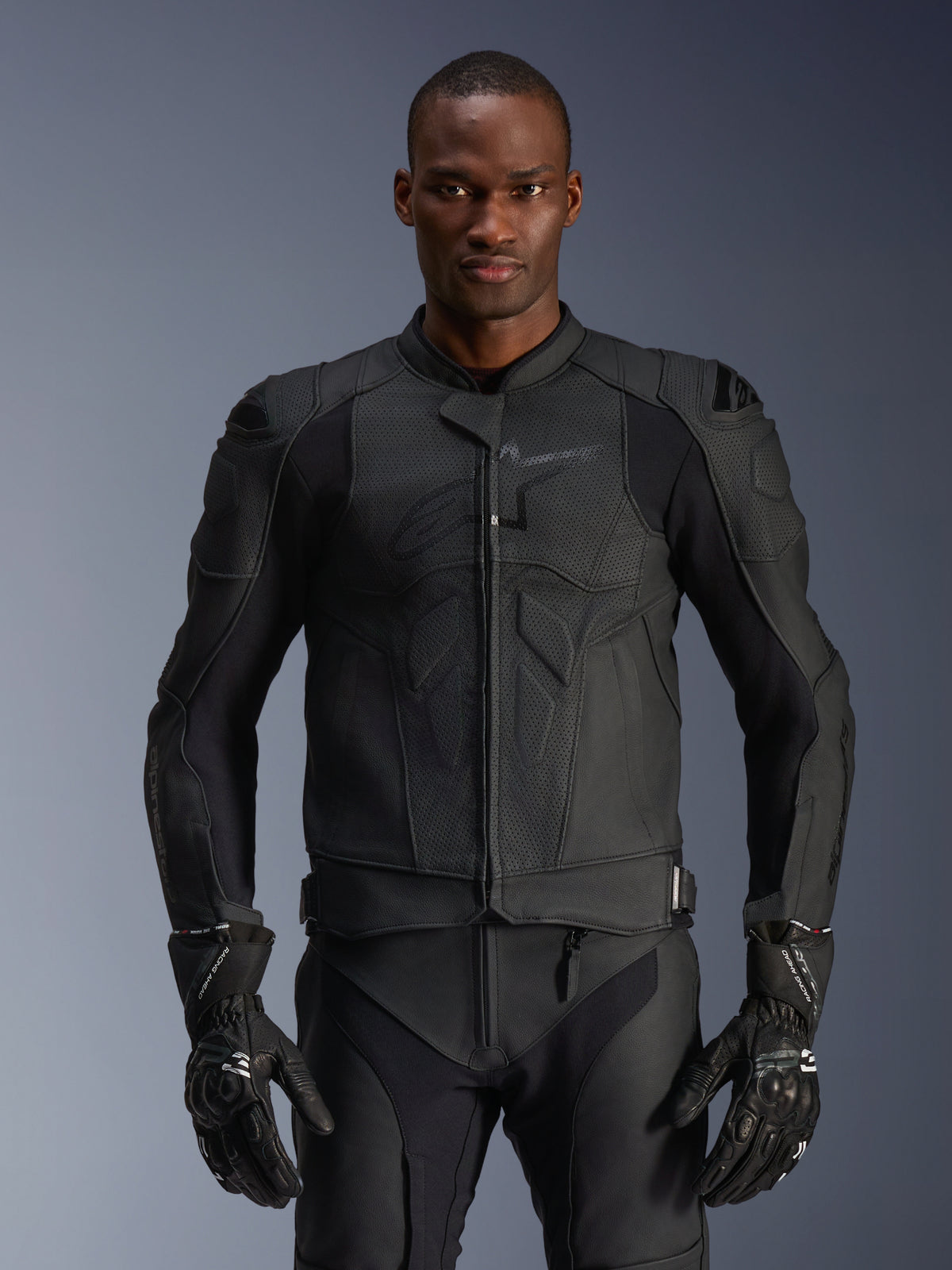 Alpinestars Dusk Airflow læderjakke, sort motorcykeljakke, perforeret læder med beskyttende polstring på skuldrene, kropsnært design, båret med matchende sorte beskyttelseshandsker