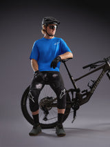 Alpinestars A-Dura Air SS jersey i blå og Black Camo shorts, vist med mountainbike og beskyttelsesudstyr i et studie.