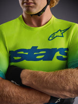 Alpinestars A-Dura ASTARS Jersey 2.0 i Yellow Fluo, kortærmet MTB-trøje med blå grafik og strækbart performance-stof.