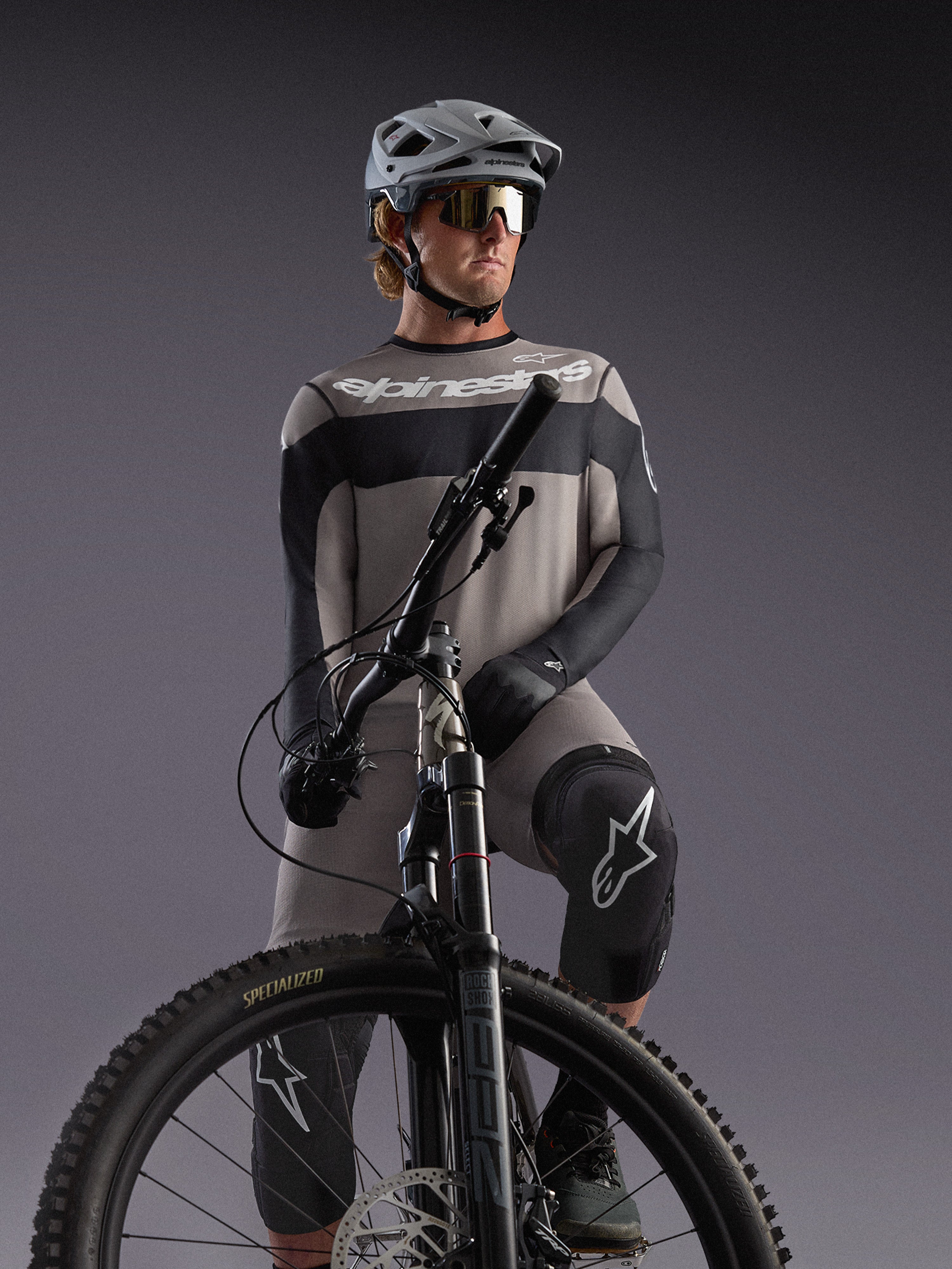 Alpinestars A-Dura Race langærmet trøje i grå på en MTB-rytter med sorte detaljer og professionelt cykeludstyr.