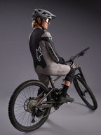 Grå Alpinestars A-Dura Race langærmet trøje på en mountainbiker, med markante logoer og strækbart performance-stof.