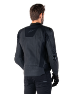 Alpinestars Missile V3 læderjakke, sort, set bagfra på model, premium racing-sportsjakke i læderkonstruktion, med præget Alpinestars-branding på den nedre ryg og TPU-albue-sliders