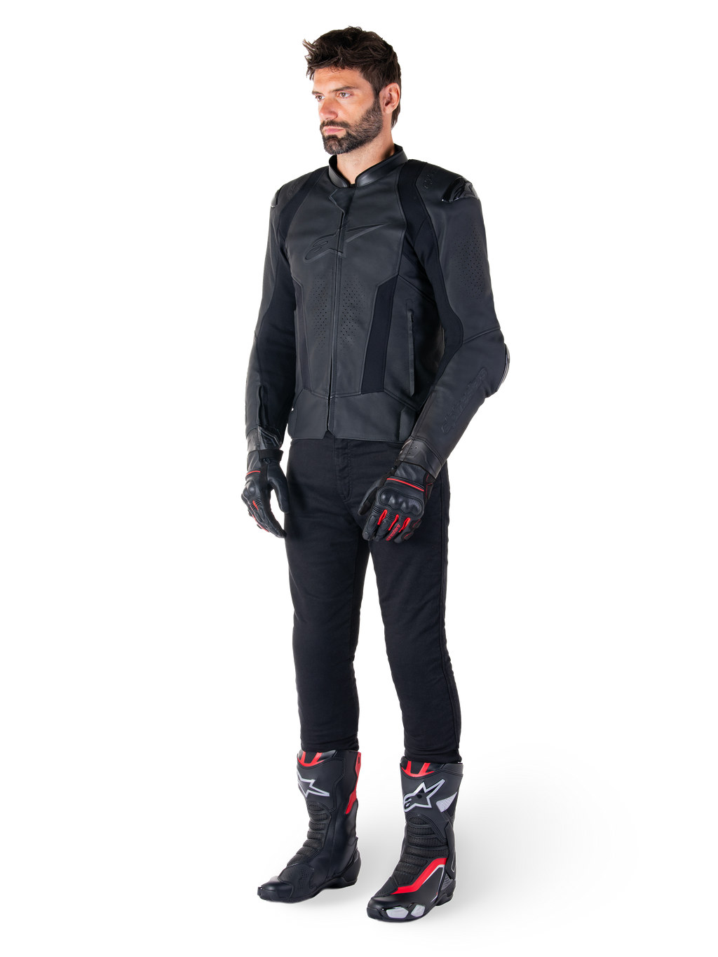 Alpinestars Missile V3 læderjakke, sort, båret af en rytter med sorte bukser og sort-røde racinghandsker og støvler, med perforerede læderpaneler og stilfuld monokromatisk branding, professionel racing sport-æstetik