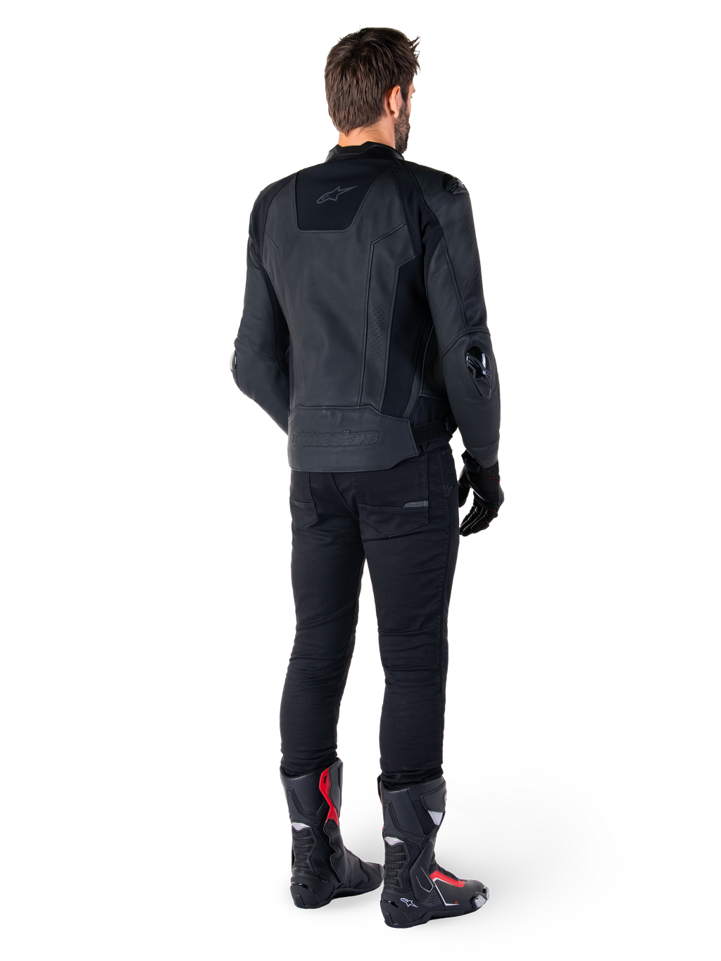 Alpinestars Missile V3 læderjakke i sort, set bagfra på en kører, båret med sorte bukser og sorte og røde racingstøvler, med strømlinet læderkonstruktion, tonalt branding og en performance race-pasform