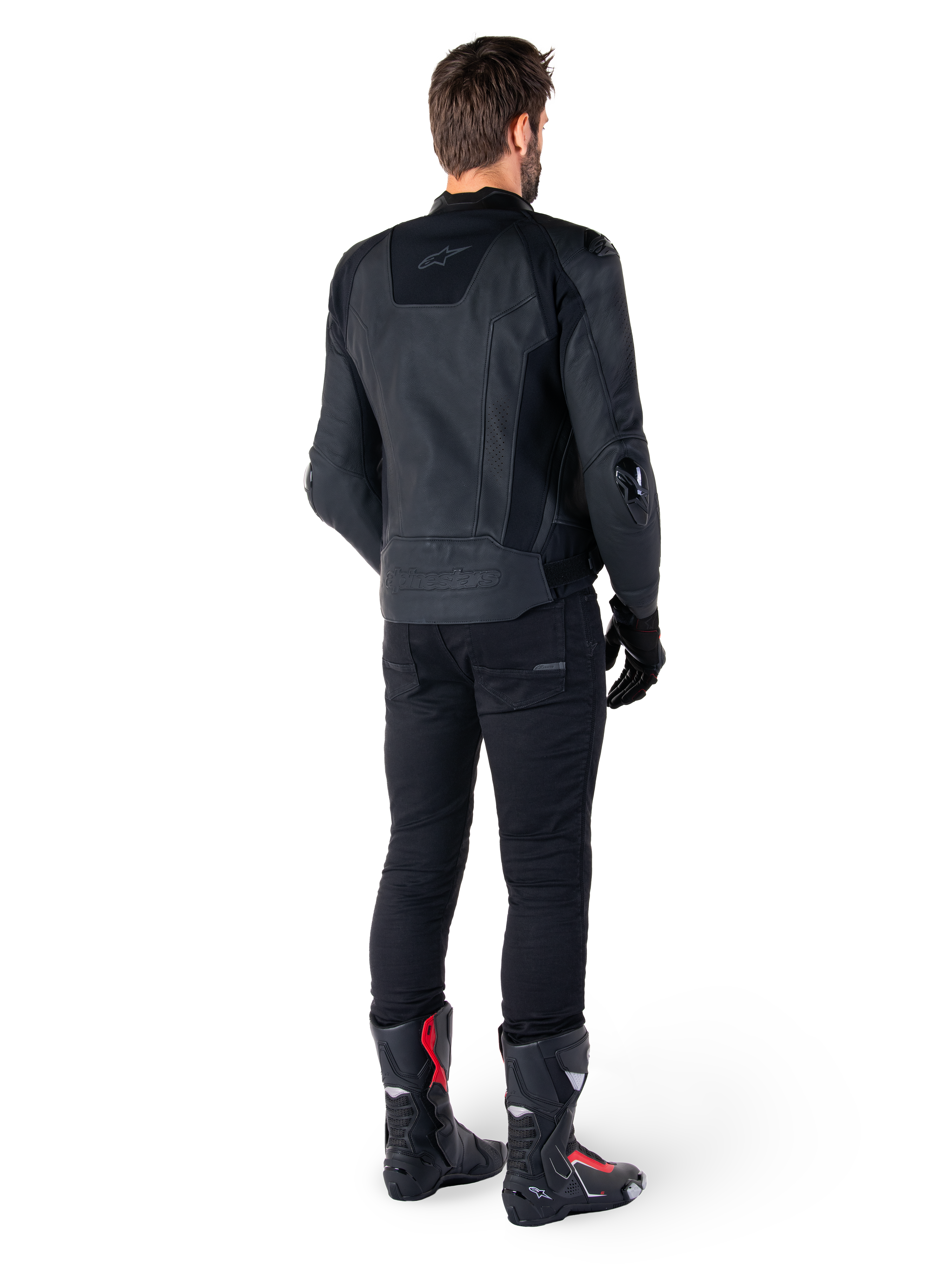 Alpinestars Missile V3 læderjakke i sort, set bagfra på en kører, båret med sorte bukser og sorte og røde racingstøvler, med strømlinet læderkonstruktion, tonalt branding og en performance race-pasform