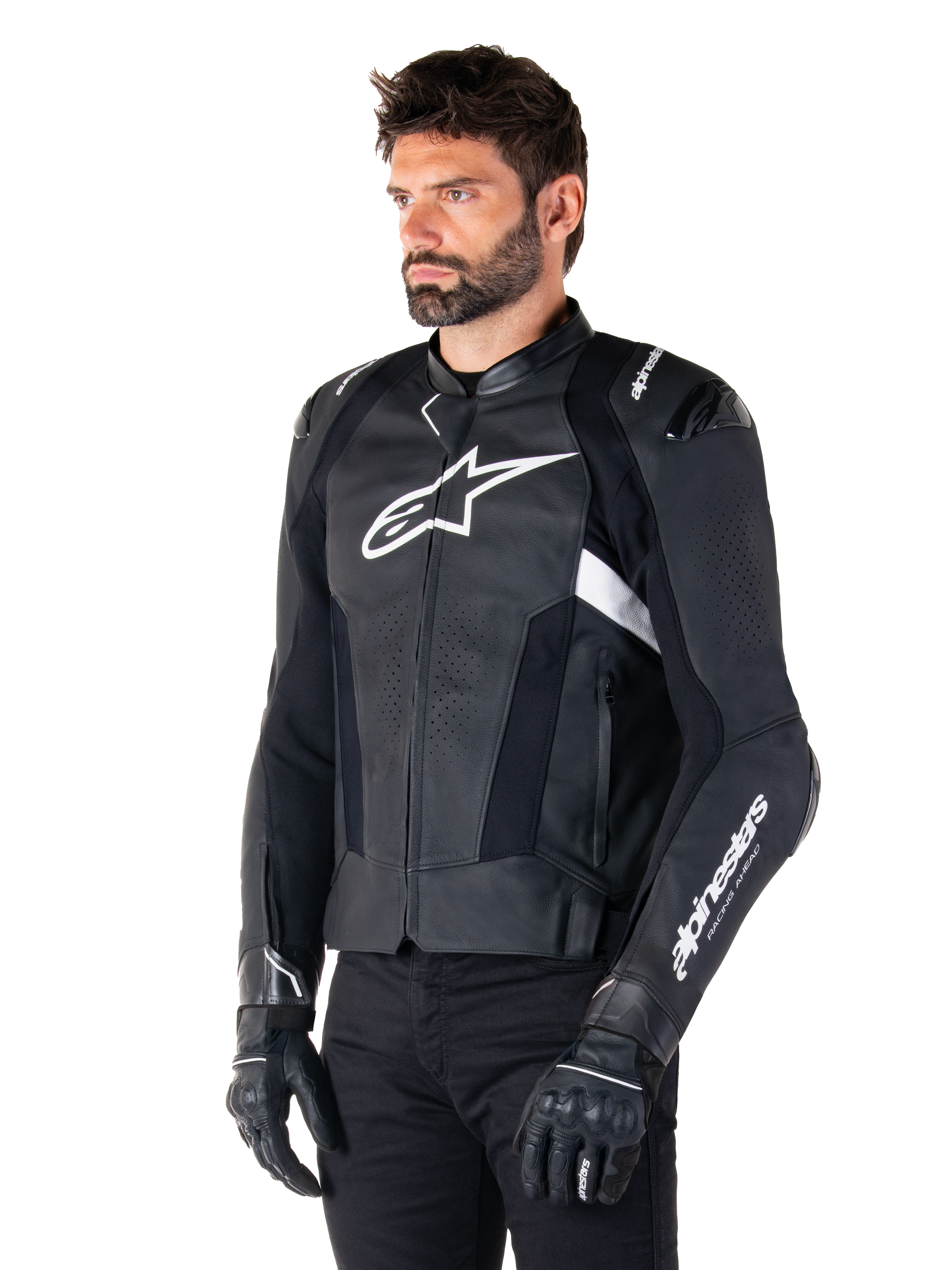 Alpinestars Missile V3 læderjakke, sort og hvid, båret af en mand med sorte kørehandsker, med et fremtrædende hvidt Alpinestars-logo på brystet, eksterne skuldersliders og perforerede paneler for et racer-inspireret look