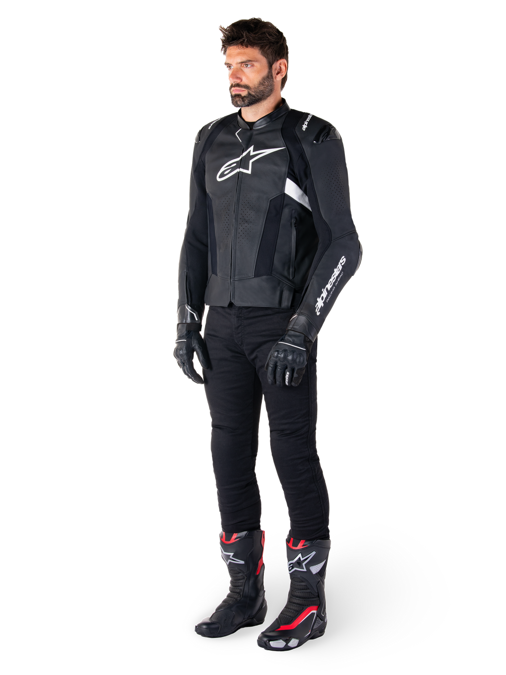 Mandlig kører iført Alpinestars Missile V3 læderjakke i sort og hvid, med hvidt brystlogo og perforerede læderpaneler, kombineret med sorte kørebukser, sorte handsker og sort-røde racingstøvler for et komplet sportskører-look.