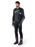 Mandlig kører iført Alpinestars Missile V3 læderjakke i sort og hvid, med hvidt brystlogo og perforerede læderpaneler, kombineret med sorte kørebukser, sorte handsker og sort-røde racingstøvler for et komplet sportskører-look.