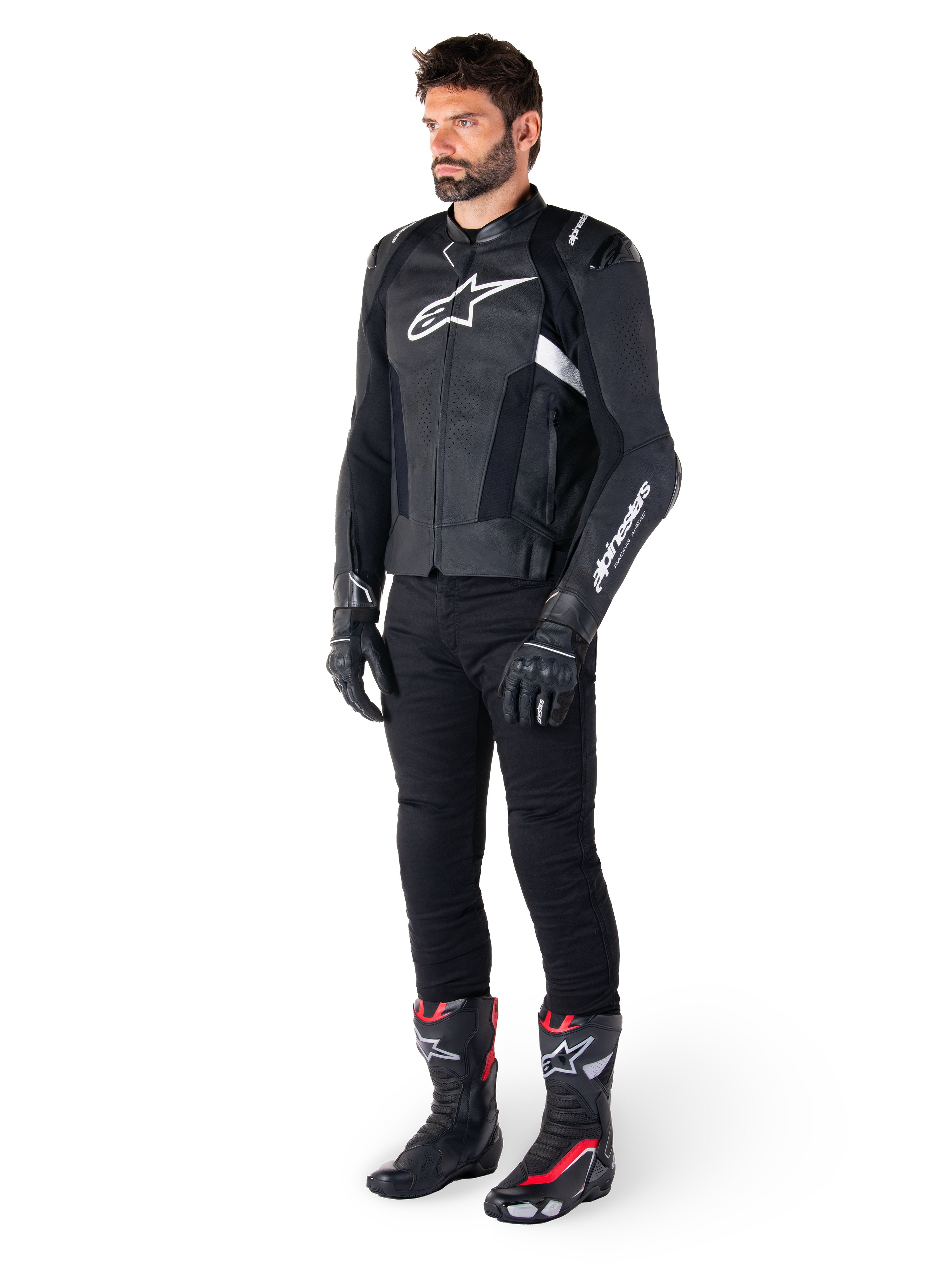Mandlig kører iført Alpinestars Missile V3 læderjakke i sort og hvid, med hvidt brystlogo og perforerede læderpaneler, kombineret med sorte kørebukser, sorte handsker og sort-røde racingstøvler for et komplet sportskører-look.