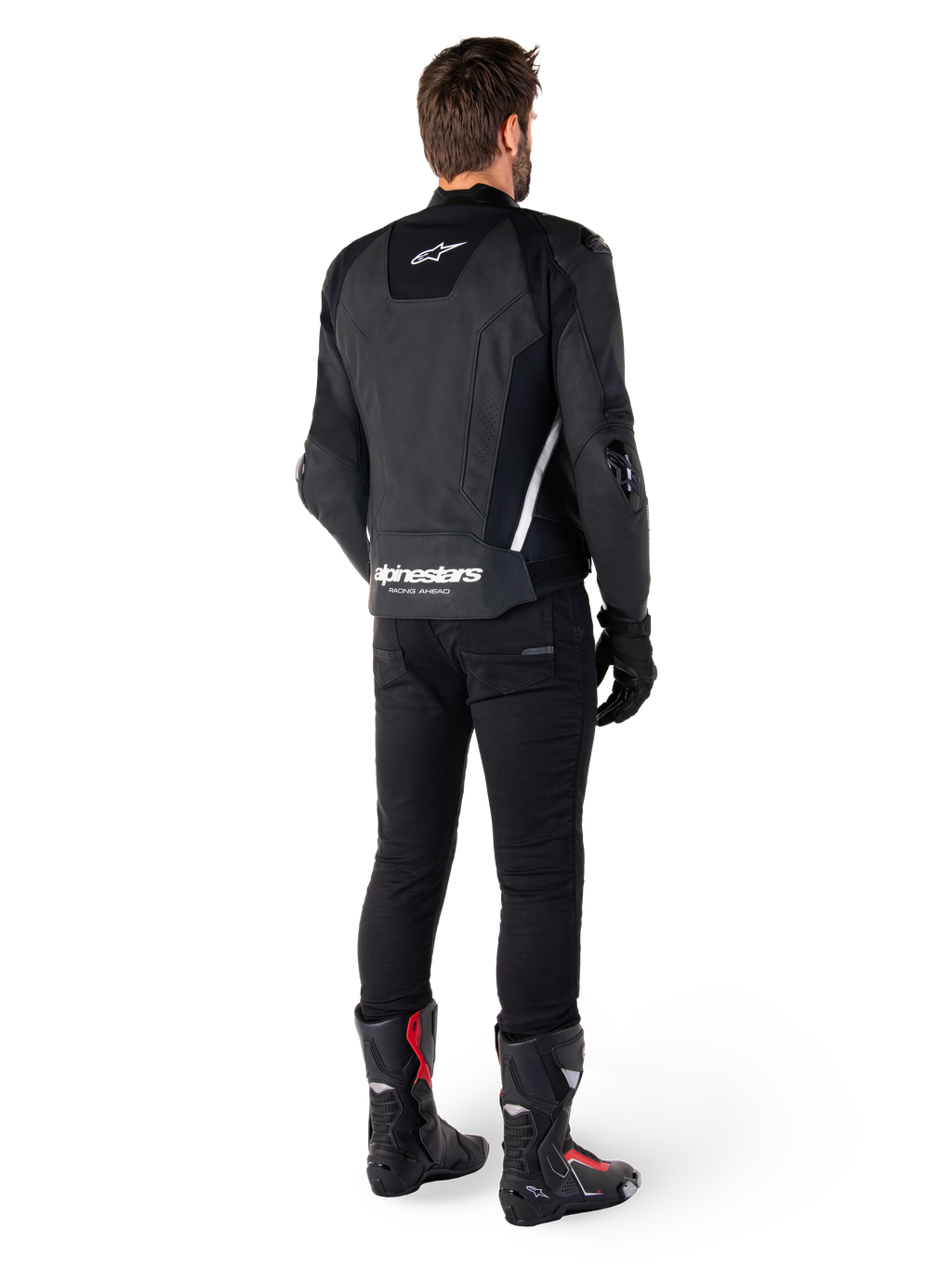 Alpinestars Missile V3 læderjakke, sort og hvid, set bagfra på køreren, med tydelig hvid Alpinestars-branding på den nederste del af ryggen og et lille logo øverst, båret med sorte bukser og racingstøvler, premium læderkonstruktion til motorcykelracing