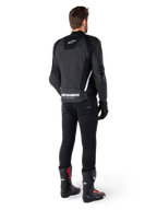 Alpinestars Missile V3 læderjakke, sort og hvid, set bagfra på køreren, med tydelig hvid Alpinestars-branding på den nederste del af ryggen og et lille logo øverst, båret med sorte bukser og racingstøvler, premium læderkonstruktion til motorcykelracing