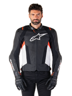 Alpinestars Missile V3 læderjakke, sort, hvid og fluorød, premium racing-sportsjakke i bovinlæder, hvidt logo på brystet og Alpinestars-branding på ærmerne, båret med sorte motorcykelhandsker og bukser