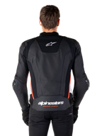 Alpinestars Missile V3 læderjakke, set bagfra, premium sort læder med rød fluo og hvide detaljer, hvidt stjernelogo på den øverste del af ryggen og Alpinestars-branding på den nederste del af ryggen, båret med sorte bukser og handsker.