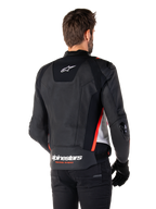 Alpinestars Missile V3 læderjakke, set bagfra på en fører, sort, hvid og fluorescerende rød, markant Alpinestars-branding og 'RACING AHEAD'-tekst på den nedre ryg, premium læderkonstruktion med tekniske strækpaneler og beskyttende TPU-skydere, vist med sorte handsker og bukser