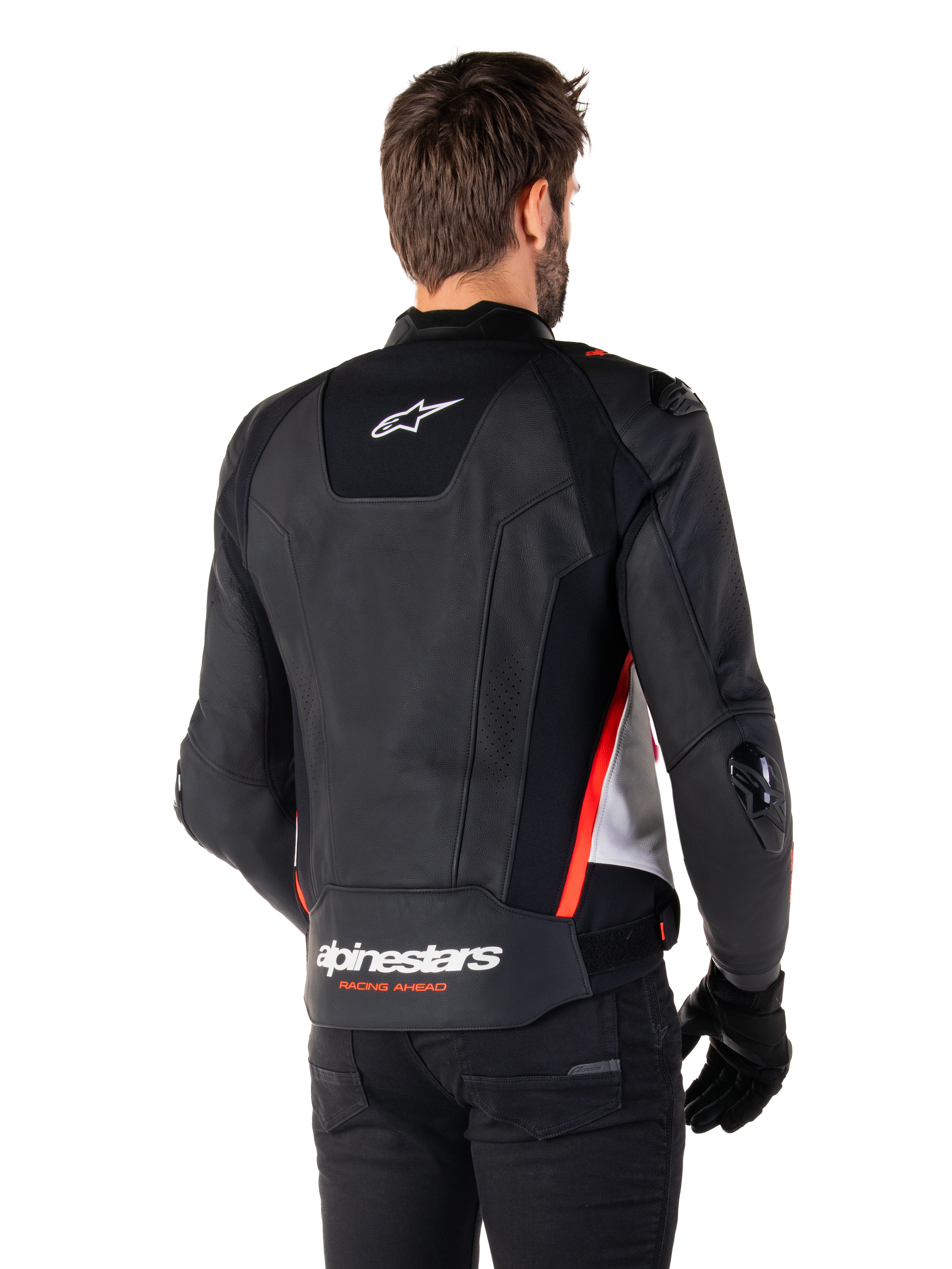 Alpinestars Missile V3 læderjakke, set bagfra på en fører, sort, hvid og fluorescerende rød, markant Alpinestars-branding og 'RACING AHEAD'-tekst på den nedre ryg, premium læderkonstruktion med tekniske strækpaneler og beskyttende TPU-skydere, vist med sorte handsker og bukser