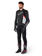 Mandlig model iført Alpinestars Missile V3 læderjakke i sort, hvid og rød fluo, kombineret med sorte motorcykelbukser, handsker og støvler, konstruktion i premium bovinlæder med tydelig Alpinestars-branding, professionel racing-sport-æstetik
