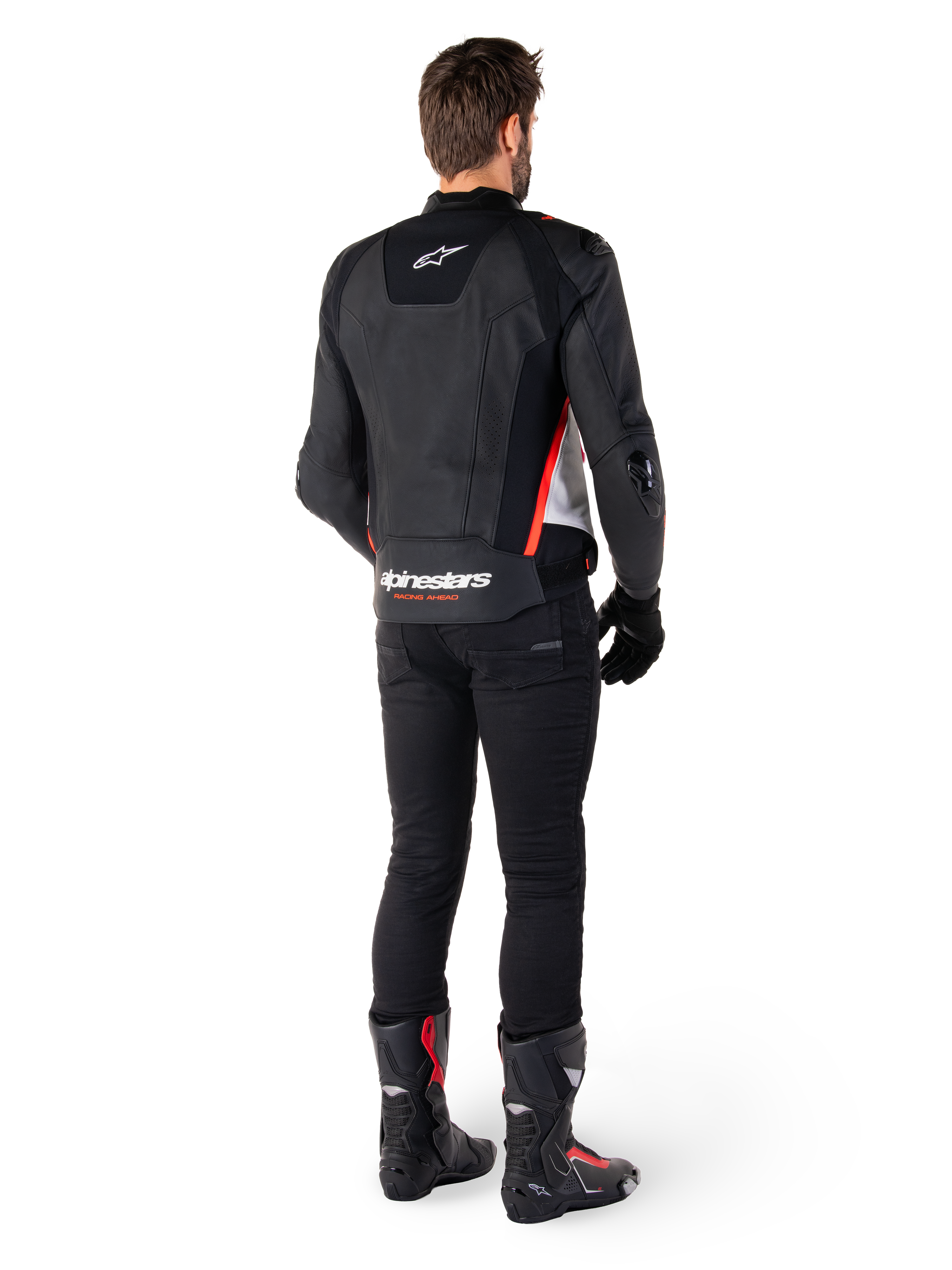 Alpinestars Missile V3 læderjakke i Sort Hvid Rød Fluo, set bagfra på en mandlig kører, med Alpinestars-branding på øvre og nedre ryg, kombineret med sorte bukser og motorcykelstøvler, racing-inspireret sportslæderjakke.