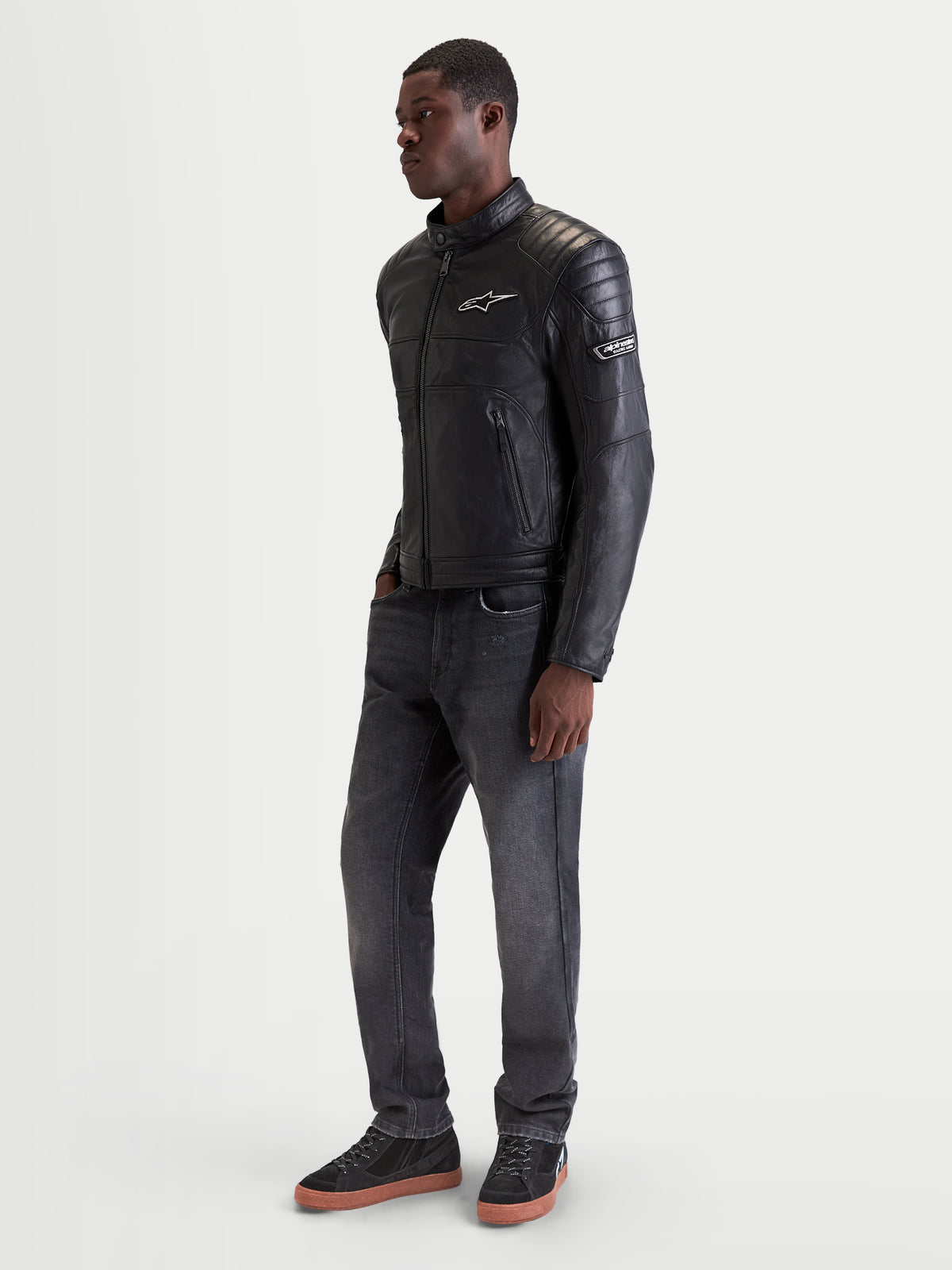 Alpinestars Revern Leather Jacket, men's urban motorcycle leather jacket in black, side profile view worn by a model showing heritage styling and full-grain bovine leather construction
