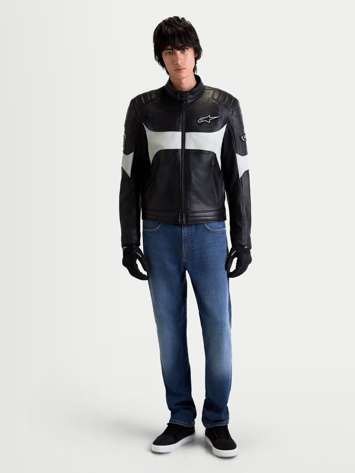 Alpinestars Revern Læderjakke, herre-urban-motorcykellæderjakke i sort og metalgrå, set forfra på model i jeans og sorte handsker, der viser heritage-design og fuldnarvslæder
