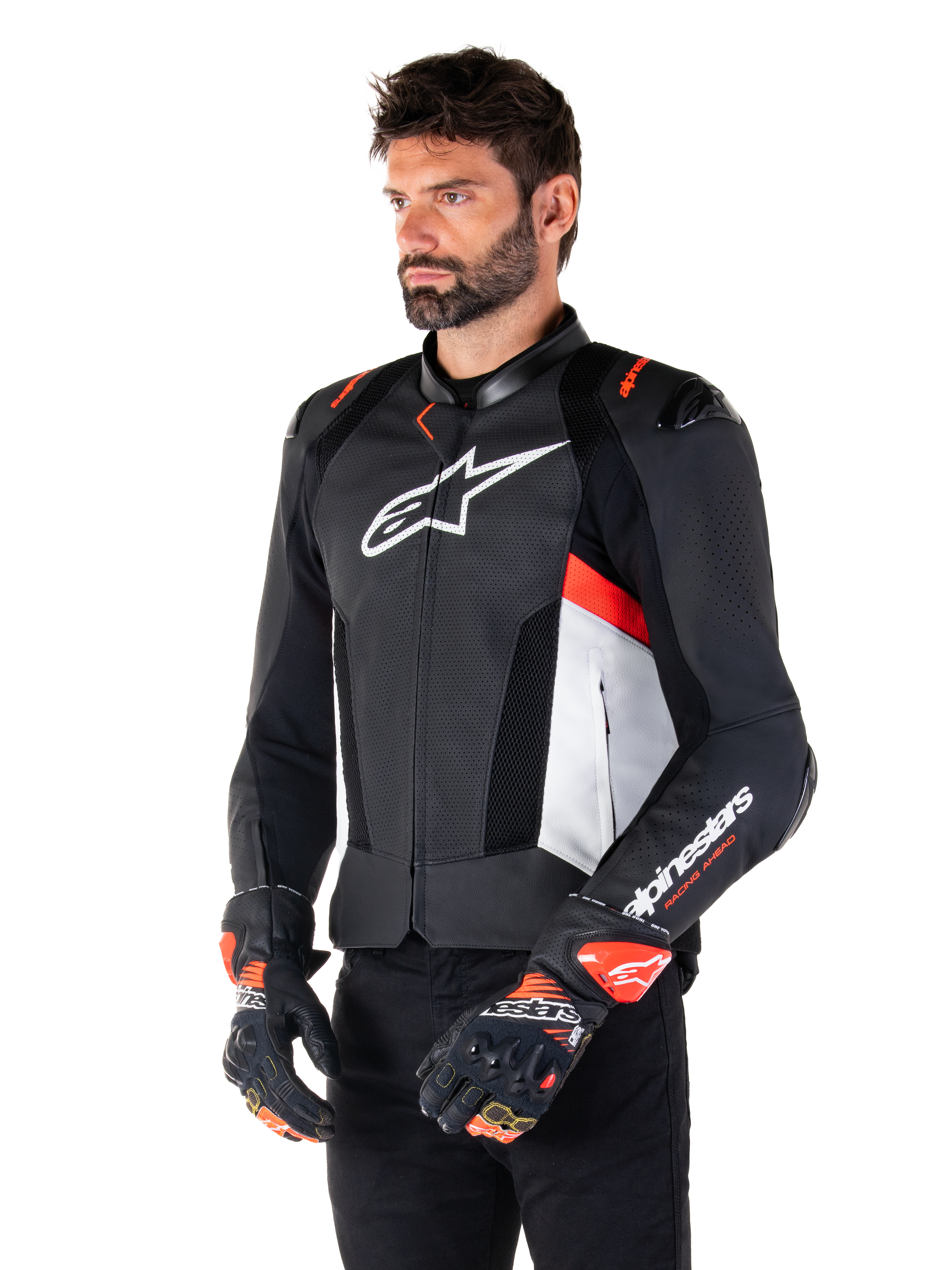 Alpinestars Missile V3 Airflow læderjakke, sort, hvid og rød fluo, racing sport motorcykeljakke, båret af model med matchende handsker, med perforerede læderpaneler, stort hvidt logo på brystet og sorte skulderbeskyttere.