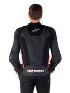 Set bagfra af en person iført Alpinestars Missile V3 Airflow læderjakke i Black White Red Fluo, med omfattende perforerede læderpaneler til ventilation, et lille Alpinestars-logo på den øverste del af ryggen og tydelig 'alpinestars RACING AHEAD'-branding nederst på taljen.