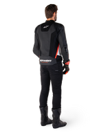 Alpinestars Missile V3 Airflow læderjakke, motorcyklist set bagfra, sort hvid rød fluo, sorte bukser og sorte støvler, perforeret læder for ventilation, DFS-beskyttelse, Alpinestars-branding på lænden.
