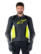 Alpinestars Missile V3 Airflow læderjakke, racing sport motorcykeljakke, sort, gul fluo og hvid, båret af en model med sorte kørehandsker, med perforeret læder på brystet, markant gult fluo-logo og hvid branding på ærmerne