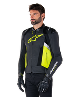 Mandlig model iført Alpinestars Missile V3 Airflow læderjakke, sort med Yellow Fluo og hvide detaljer, perforeret læder for maksimal ventilation, markant gult logo på brystet, kombineret med sorte handsker og bukser, sports- og racing-motorcykeludstyr